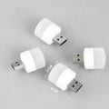 Four compact USB LED night lights with white diffusers on a grey background, size shown as 2x4 cm.